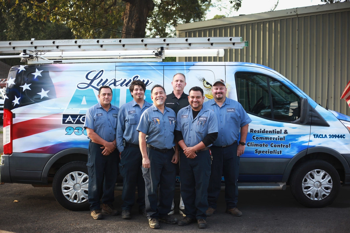 Team of HVAC specialists standing in front of their Luxury air service van in Conroe, TX