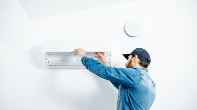 Tech Adjusting An Air Conditioner