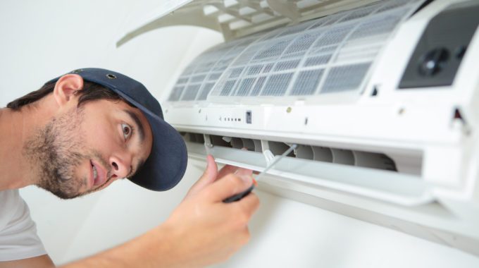 A Person Fixing A Air Conditioner